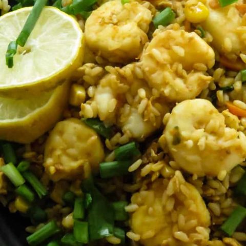 easy shrimp fried rice in a plate with lime wedges