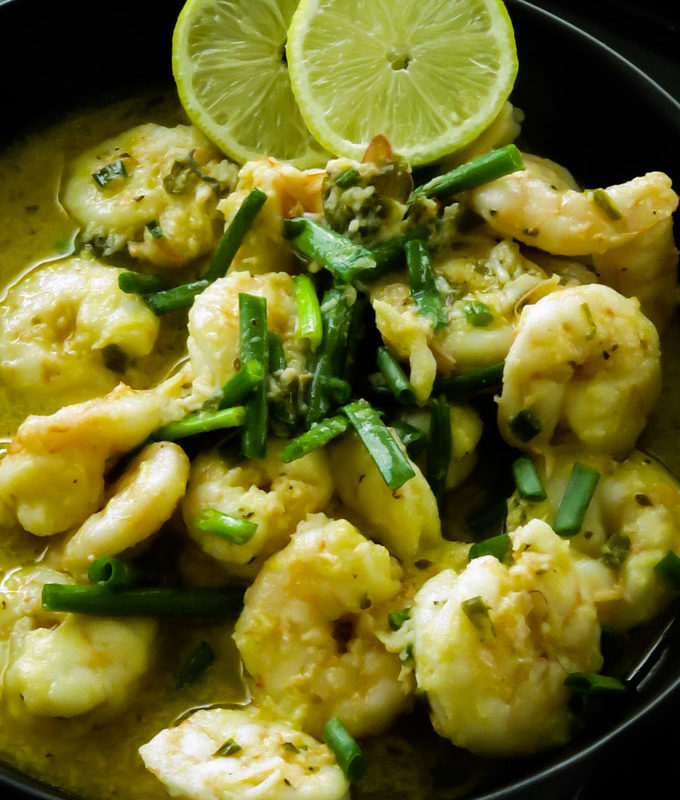 garlic butter shrimp in a bowl served with lime wedges
