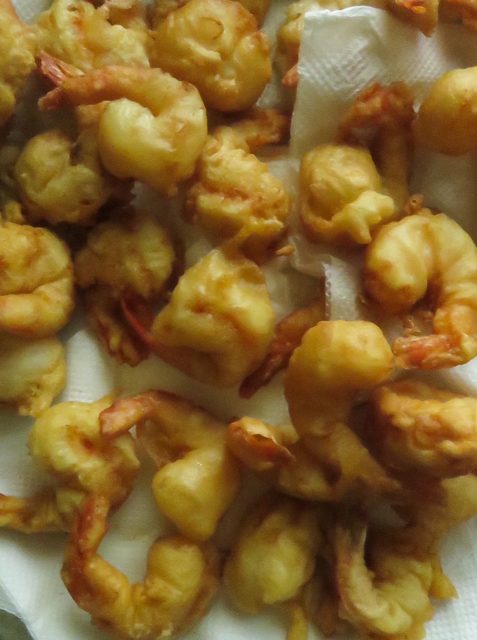 fry the battered shrimp and place them in kitchen paper towel to soak excess oil.