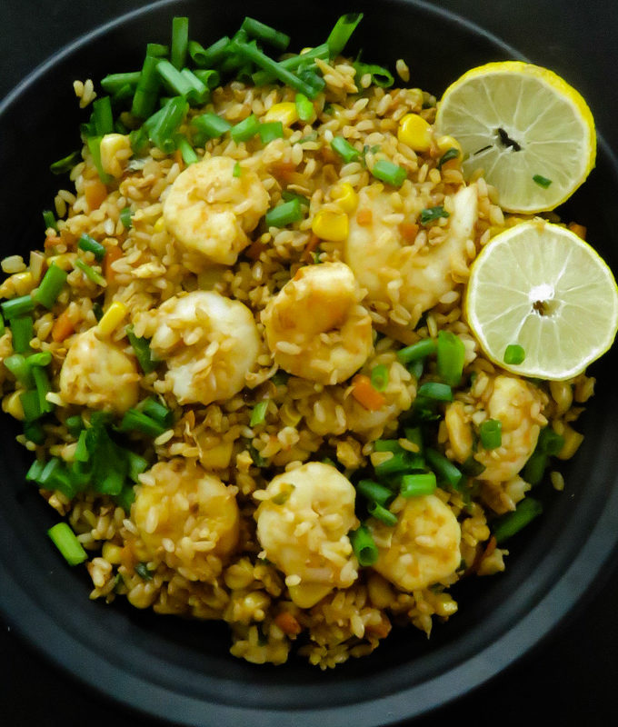 tasty shrimp fried rice served with lime on a plate.