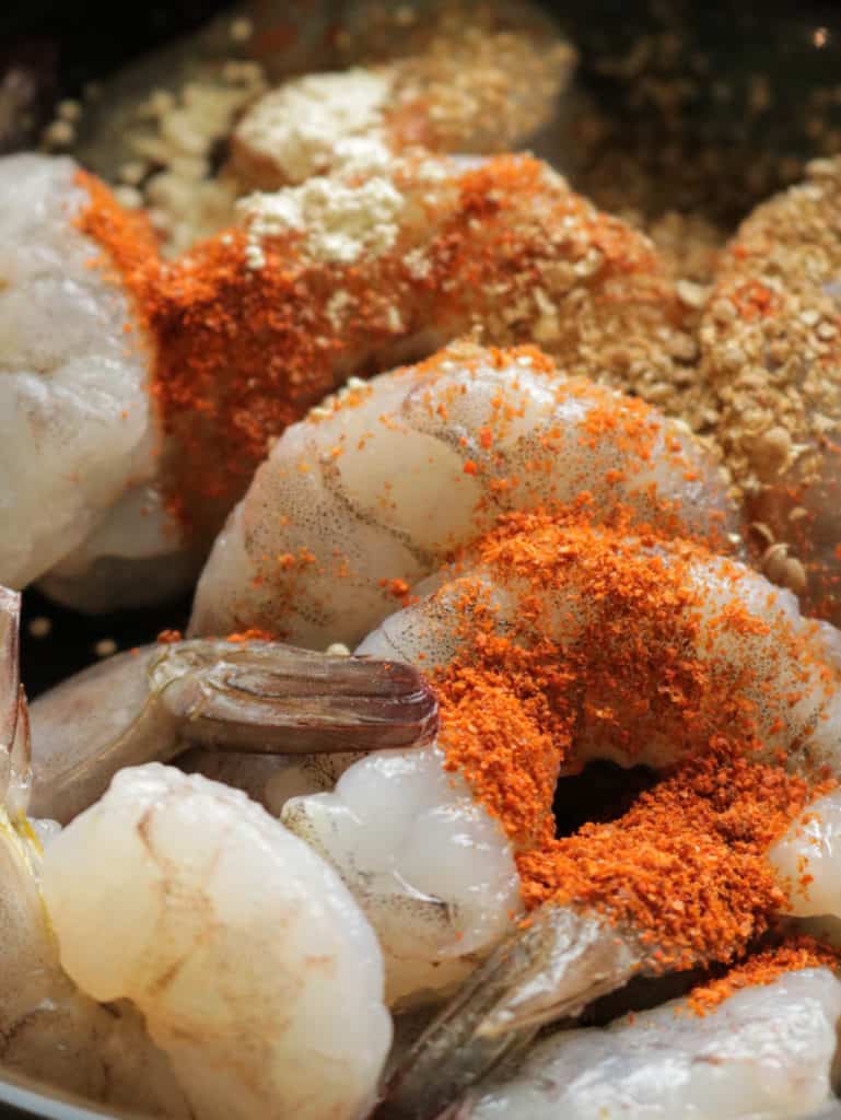 seasoning the shrimp to sautee.