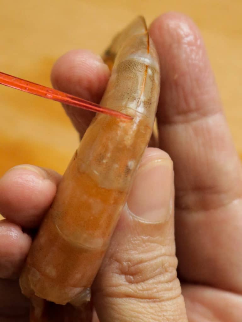 inserting toothpick or cocktail stick to devein shrimp