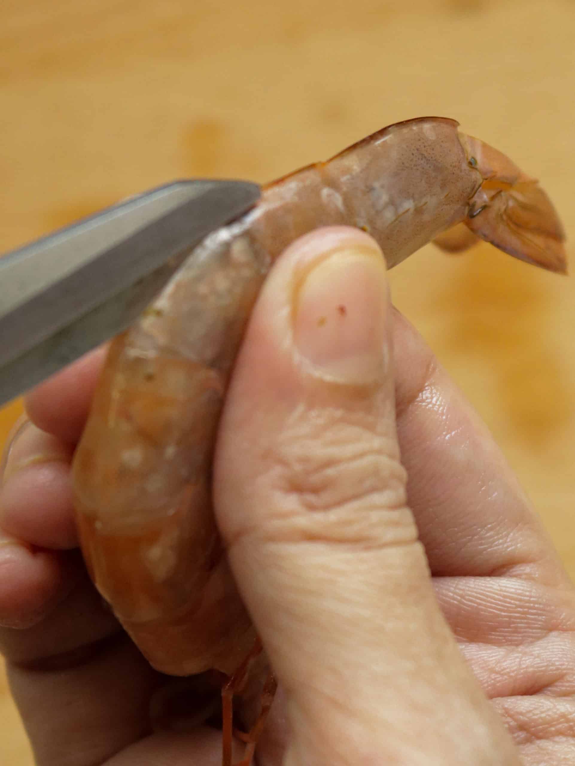 cutting the shrimp with the scissor to remove the shell of the shrimp