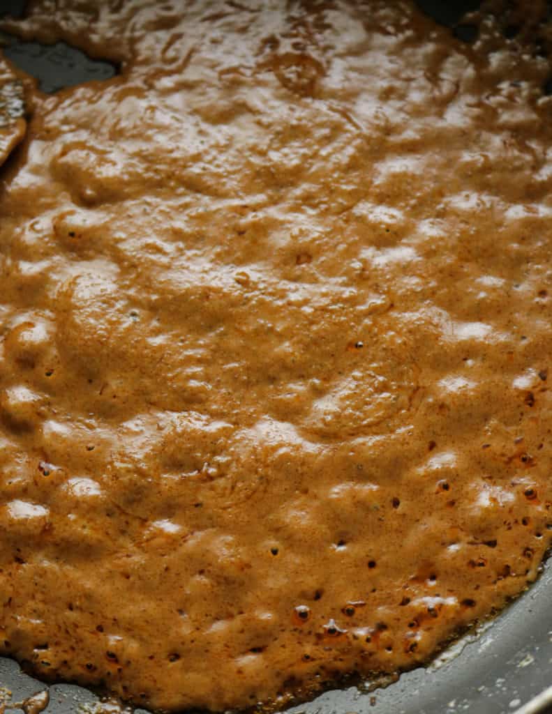 thickening the thai coconut curry paste to make the shrimp curry.