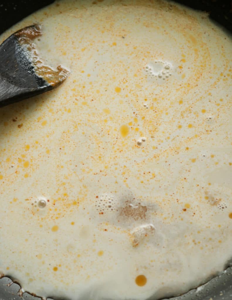 adding more coconut milk to make the thai shrimp curry.