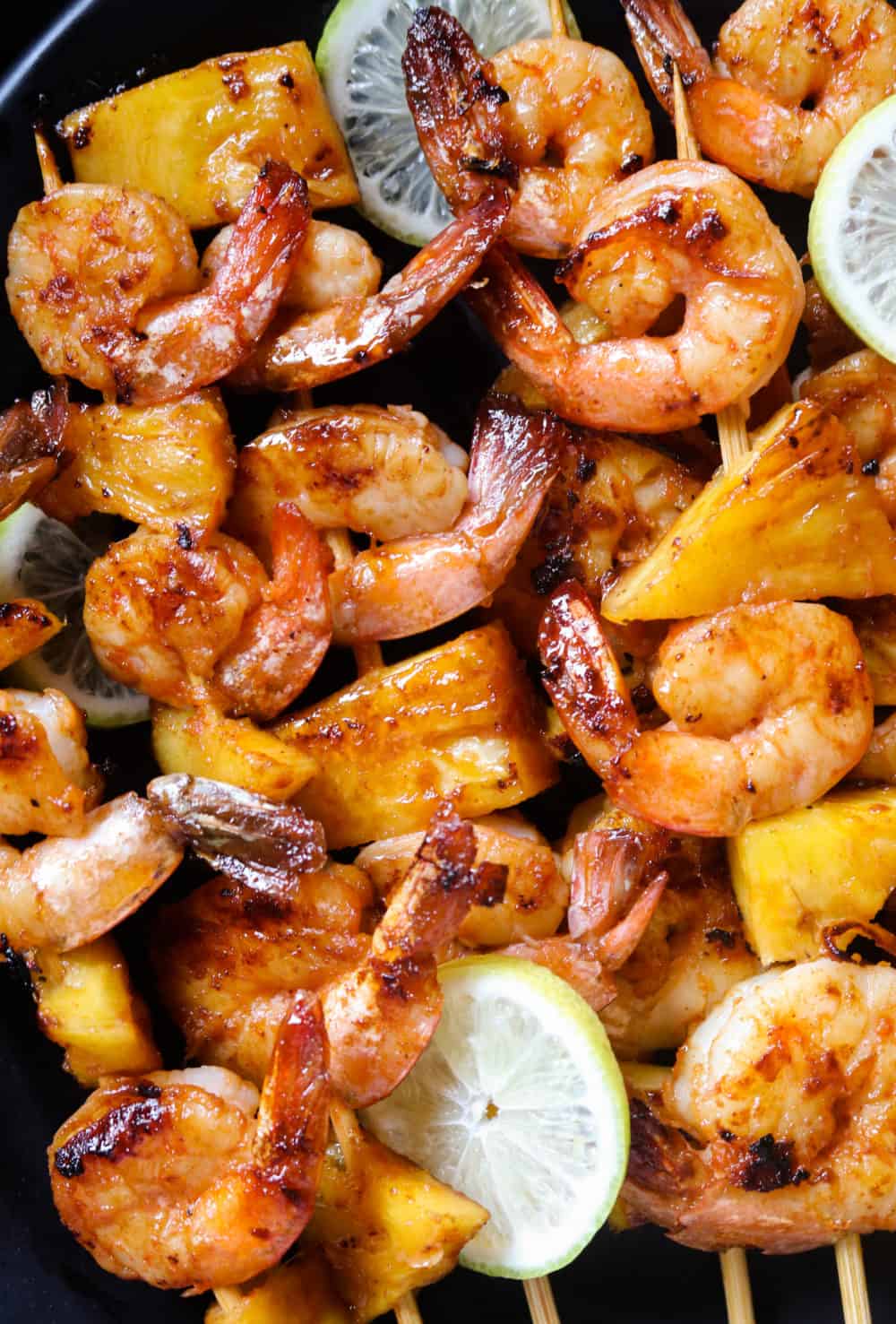 pineapple shrimp skewers with lime wedges..