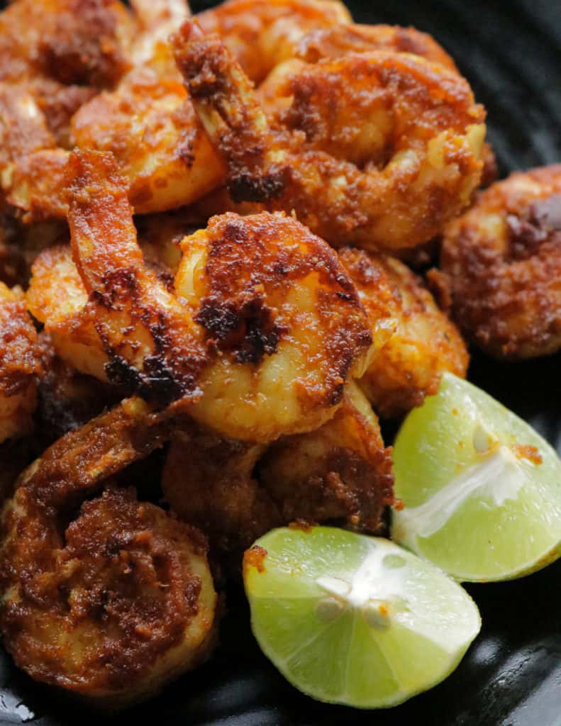 tandoori shrimp served with lime wedges.