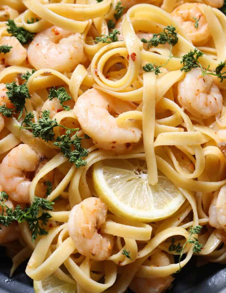 lemon shrimp pasta with garnish and placed in a black platter.