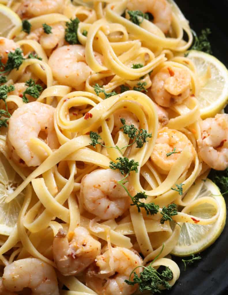 creamy lemon shrimp pasta with garlic garnished with parsley.