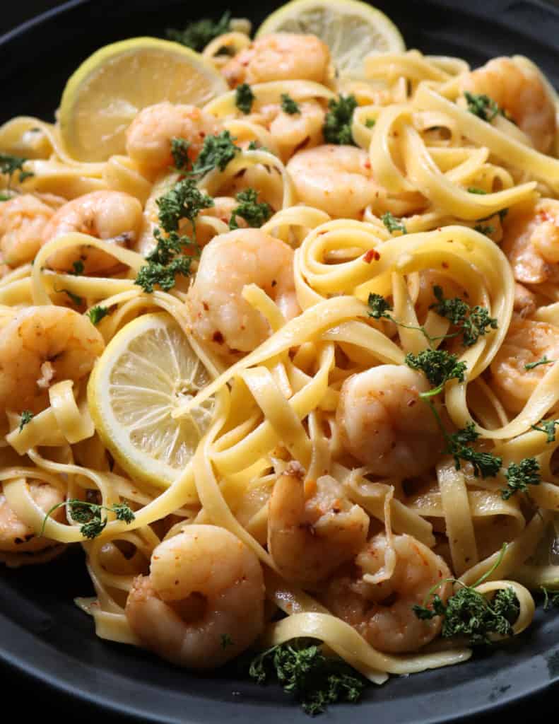 lemon shrimp pasta with slices of lemon and shrimp placed in a platter.