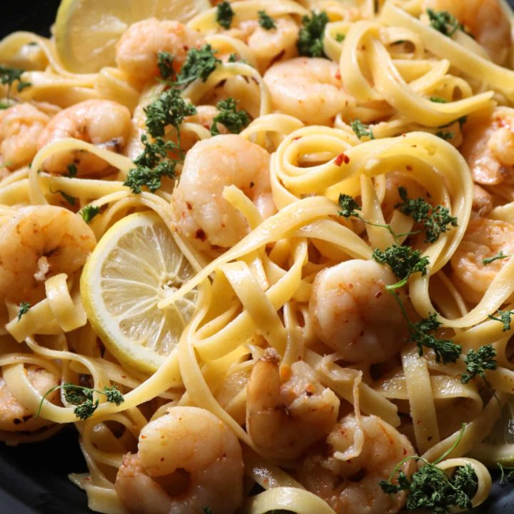 garlic shrimp lemon pasta with slices of lemon.