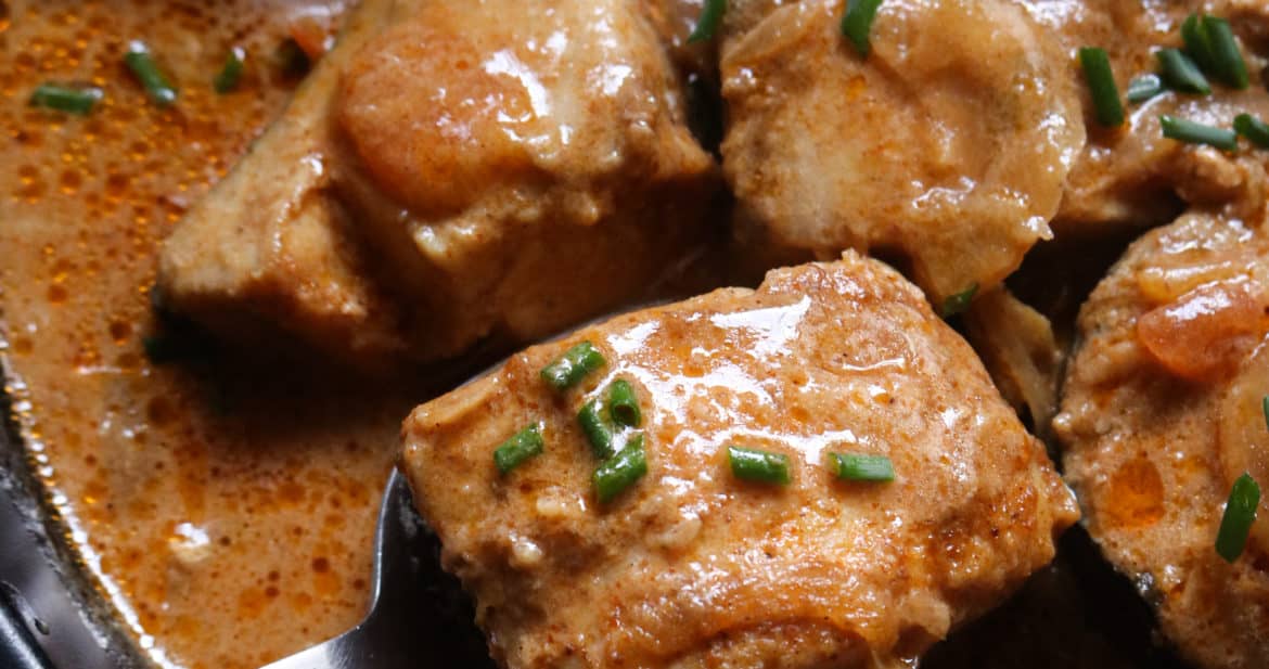 Indian fish curry, a spoon scooping a fish cube.