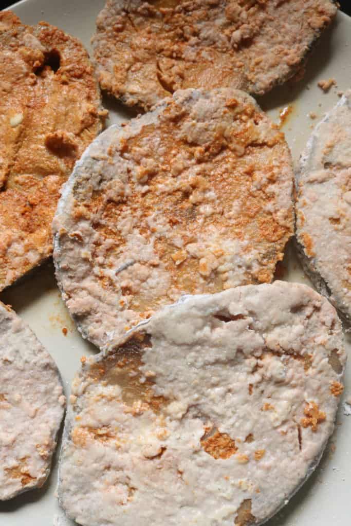 fish steaks with marination and flour coating ready to be fried.