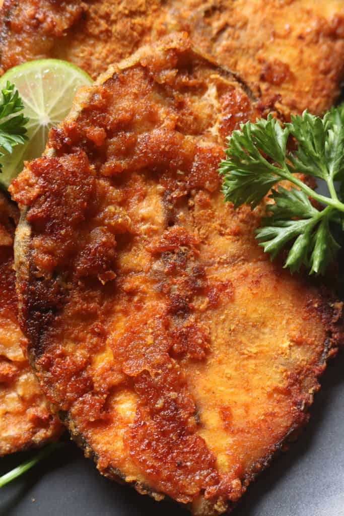 Fried fish steak with parsley as garnish.