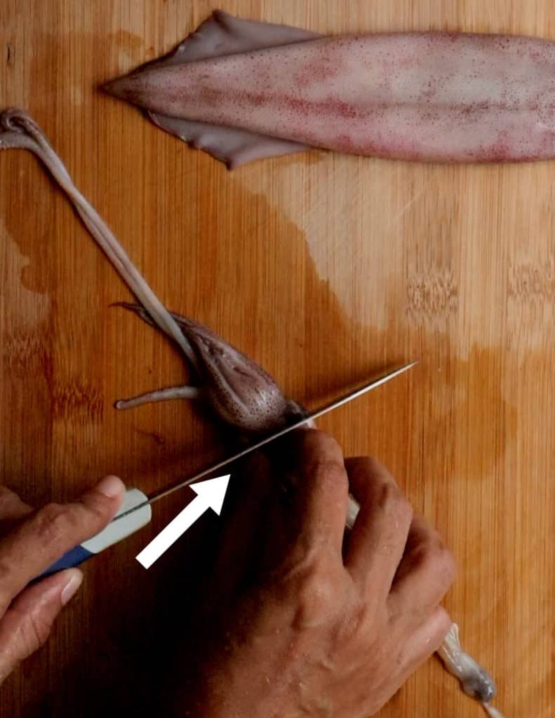 cutting and separating the head from the innards with a sharp knife.