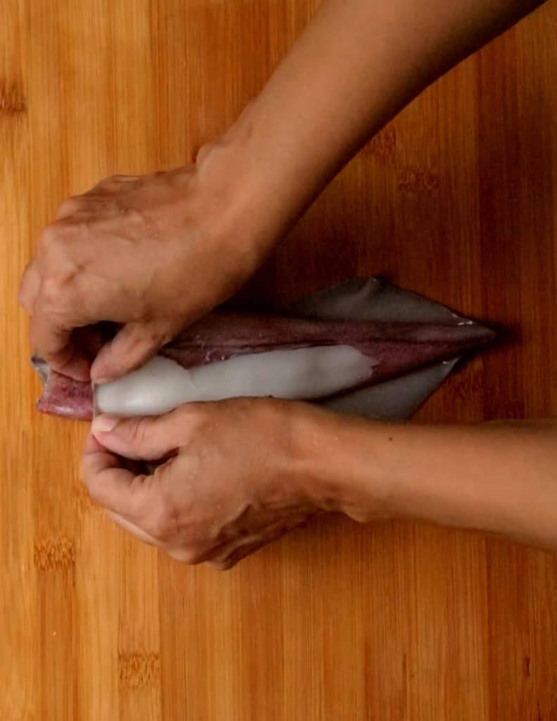 peeling off the skin of the squid.