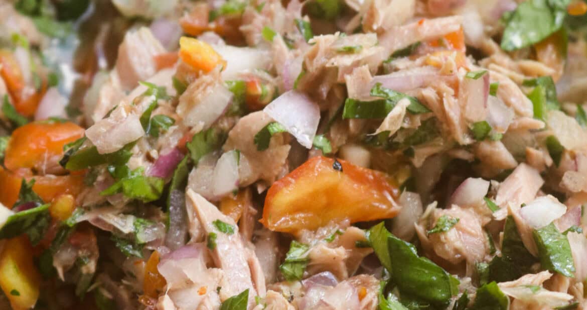 canned tuna ceviche with coriander,onions and tomato served in a bowl.